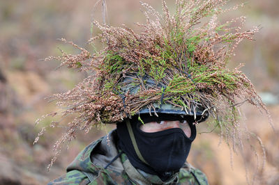 Portrait of soldier with plant on helmet