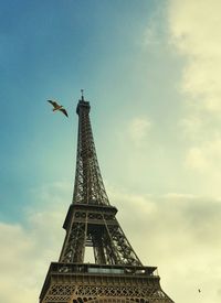 Low angle view of a monument and a bird in flight.