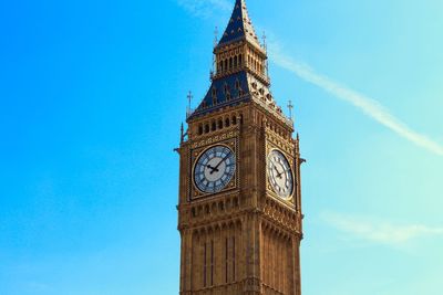 Low angle view of clock tower against blue sky