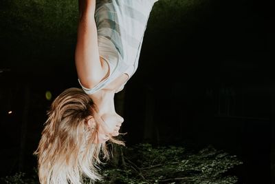 Upside down image of young woman with tousled hair at night