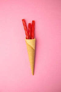 High angle view of colored pencils against pink background