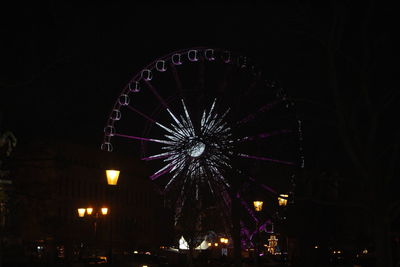 Low angle view of illuminated ferris wheel against sky at night