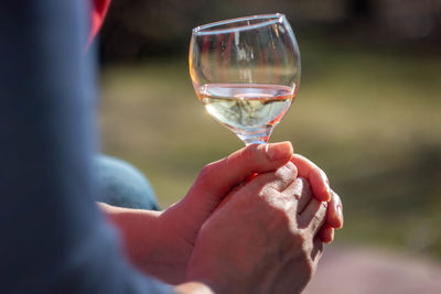 A woman is sitting on a terrace with a glass of tokay wine in her hands