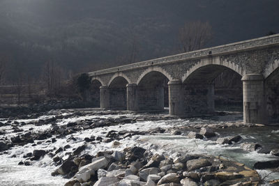 Arch bridge over river during winter