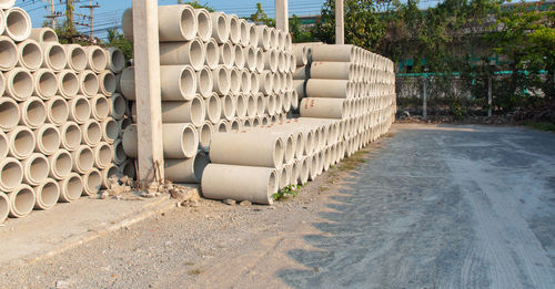 Stack of pipes on wall by plants