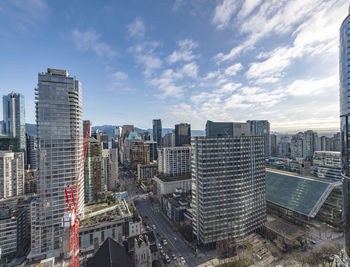 View of buildings in city against cloudy sky