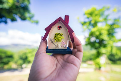 Small houses on hand, natural background, real estate and property concept.