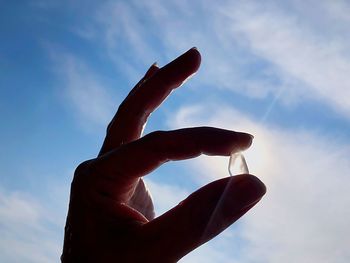 Low angle view of hand against sky