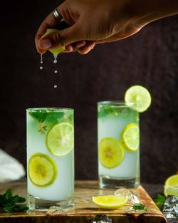 Cropped hand of woman holding drink on table