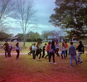 Group of people on field against trees