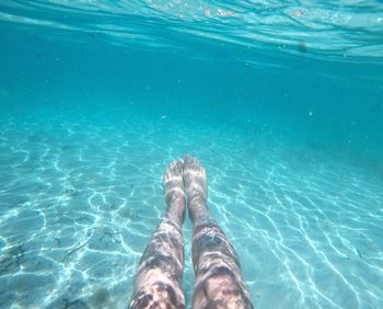 Low section of woman relaxing in swimming pool