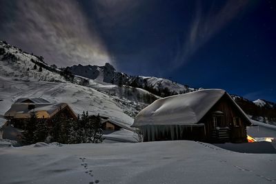 Scenic view of snow covered mountain against sky at night