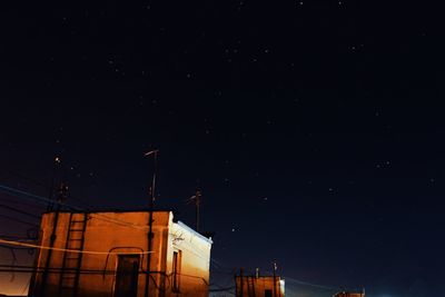 Low angle view of illuminated building against sky at night