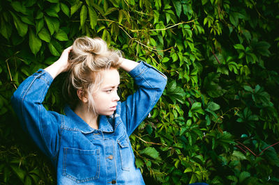 Close-up of young woman against plants