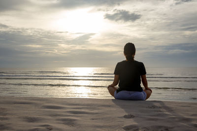 Rear view of man relaxing on beach