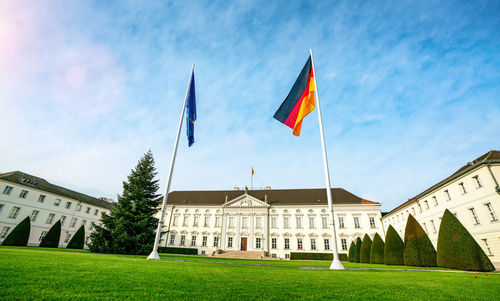 Flag on lawn of building against sky