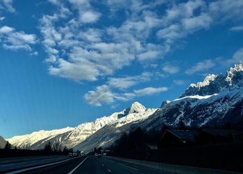 Road amidst snowcapped mountains against sky