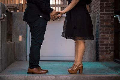 Low section of couple standing in hands