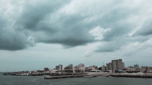 City by sea against storm clouds