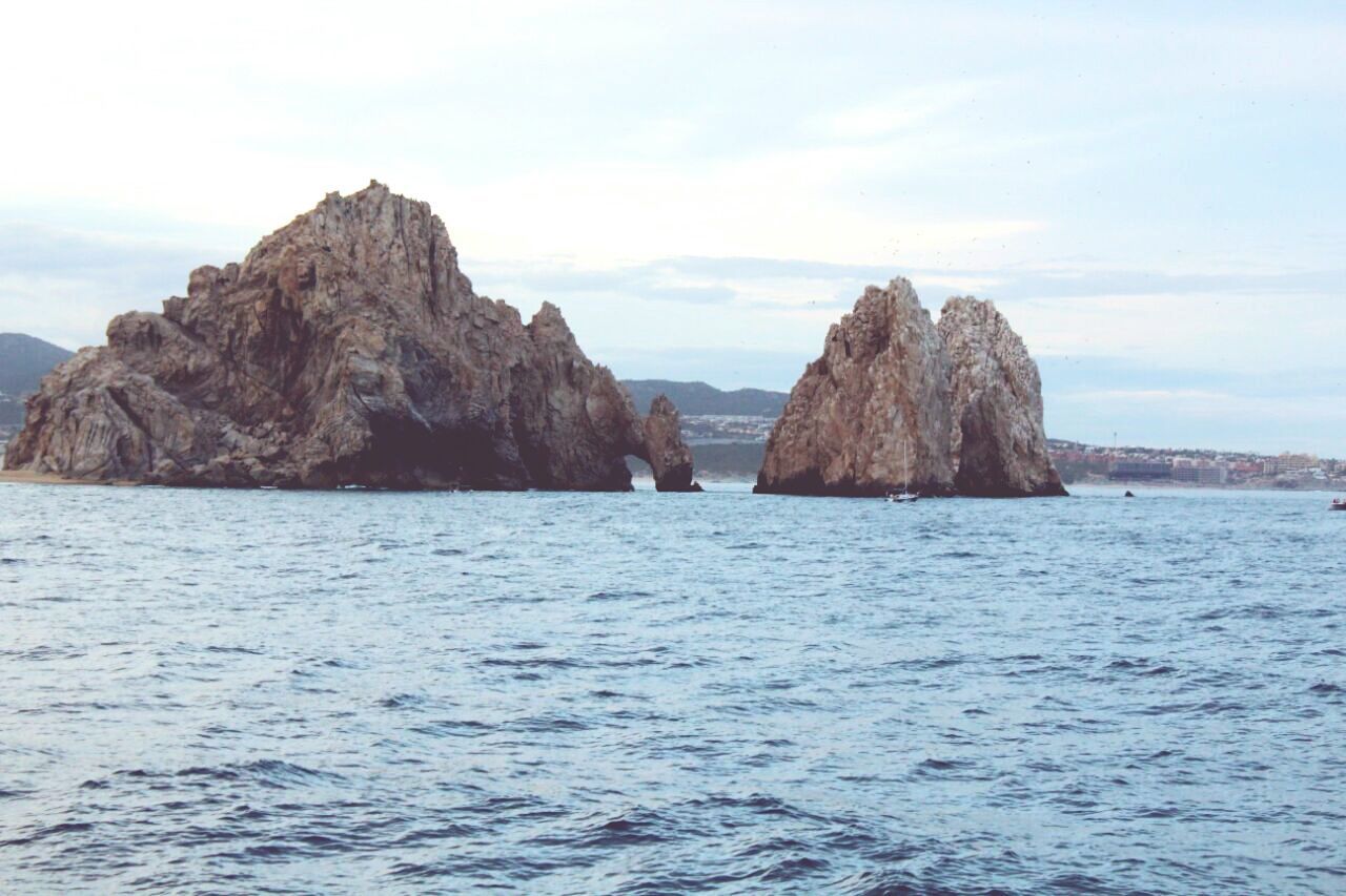 sea, water, scenics, tranquil scene, rock formation, tranquility, beauty in nature, sky, waterfront, rock - object, nature, cliff, rock, mountain, idyllic, rippled, horizon over water, geology, cloud, remote