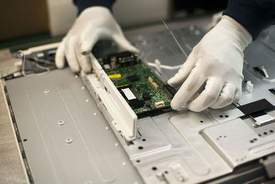 High angle view of cropped man making mother board in factory