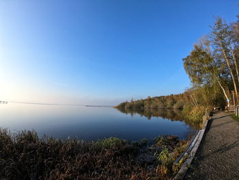 Scenic view of lake against clear blue sky