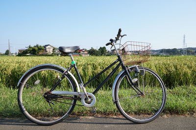 Bicycle on field against clear sky