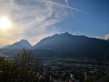 Aerial view of townscape and mountains against sky