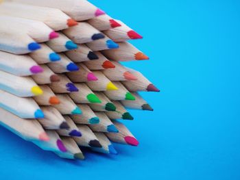 Close-up of multi colored pencils against blue background