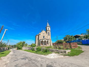 Stone ancient church on background of blue sky in countryside. stone stairs, arched windows