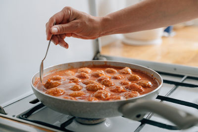 Cropped hand of person preparing food in kitchen