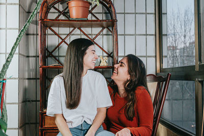 Smiling lesbian women sitting on chair