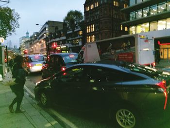 Man in car against illuminated city