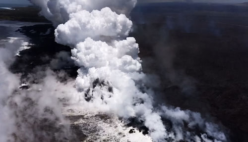 Smoke emitting from volcanic mountain against sky