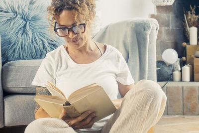 Young woman using laptop while sitting on sofa at home