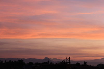 Silhouette mountain against dramatic sky during sunset