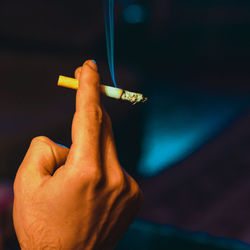 Close-up of hand holding cigarette