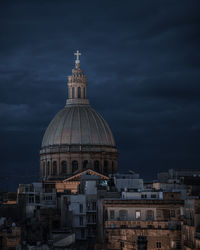 View of buildings in city against cloudy sky