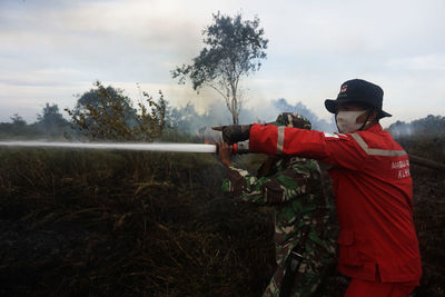 Rear view of firefighter working on field