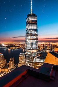 Modern buildings in city against sky at night