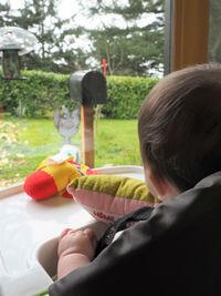 Rear view of boy sitting outdoors