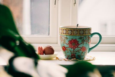 Close-up of cup on window sill