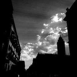 Low angle view of buildings against cloudy sky