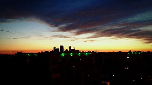 Silhouette of buildings against sky at sunset