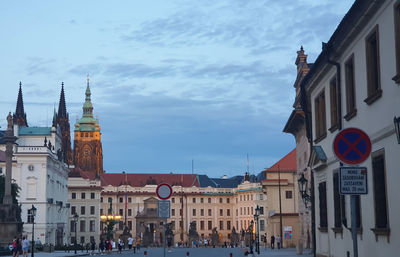 Buildings in city against cloudy sky