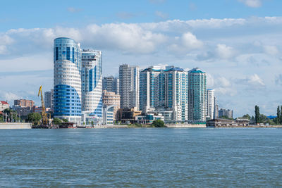 Against the background of the river, offices and modern multi-storey buildings.