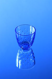 Close-up of glass of water against blue background