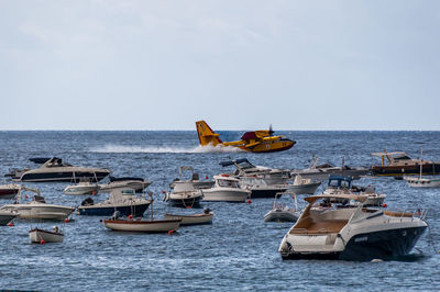 Boats in sea against sky