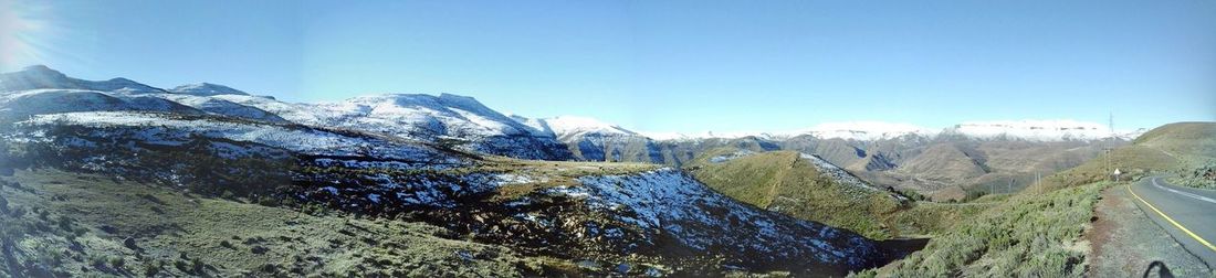 Scenic view of mountains against blue sky