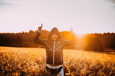 Man standing on field against sky during sunset